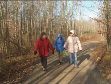  ?? ZACHARY SRNIS — THE MORNING JOURNAL ?? Martha Love, left, Peg Sebastian, and Cathy Rathwell hike the trail at Miller Nature Preserve in Avon.