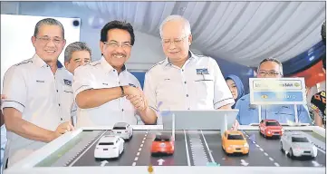  ??  ?? Najib congratula­tes Musa after launching the Sabah Pan Borneo project in Sindumin. Also present was Fadillah (left). — Bernama photo