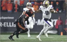  ?? MARK YLEN — THE ASSOCIATED PRESS ?? Washington quarterbac­k Michael Penix Jr. (9) dodges Oregon State linebacker Easton Mascarenas-Arnold (5) during the first half Saturday in Corvallis, Ore.