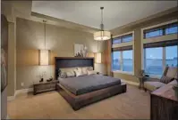  ??  ?? The master bedroom has a tray ceiling and large windows.