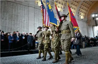  ?? VIRGINIA MAYO / ASSOCIATED PRESS ?? Re-enactors dressed in U.S. World War I uniforms march during an Armistice ceremony at the Menin Gate in Ypres, Belgium, on Sunday to mark exactly 100 years since the end of World War I. Almost 10 million soldiers died in WWI, sometimes tens of thousands on a single day.