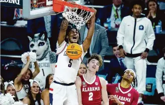  ?? Ross D. Franklin/Associated Press ?? UConn guard Stephon Castle (5) dunks over Alabama forward Grant Nelson (2) during the second half of the NCAA college basketball game at the Final Four on Saturday in Glendale, Ariz.