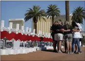  ?? ?? People pray at a makeshift memorial for shooting victims in Las Vegas.