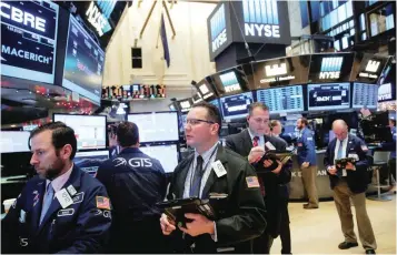  ?? — Reuters ?? Traders work on the floor at the NYSE in Manhattan, New York City.