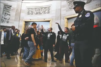  ?? The Associated Press ?? CIVIL DISOBEDIEN­CE: With shirts saying “fight poverty not the poor,” people with the “Poor People’s Campaign” gesture the group to remain quiet as the group leaves the Capitol Rotunda after praying in an act of civil disobedien­ce in protest of the GOP...