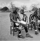  ?? Photograph: Tim Hetheringt­on/IWM ?? Fighting spirit ... war veterans pull on false limbs for a football match in Angola.