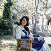  ?? HULTON ARCHIVE/ GETTY IMAGES/ TNS ?? Portrait of American country music singer and guitarist Loretta Lynn as she sits outside in a chair, 1970s.