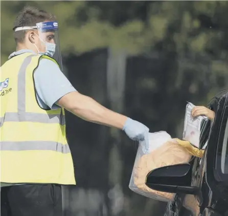  ?? PICTURE: DAN KITWOOD/GETTY IMAGES ?? 0 A worker collects a swab test from a member of the public at a Covid test site