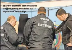  ??  ?? Board of Elections technician­s fix clogged polling machines at 177 Myrtle Ave. in Brooklyn.