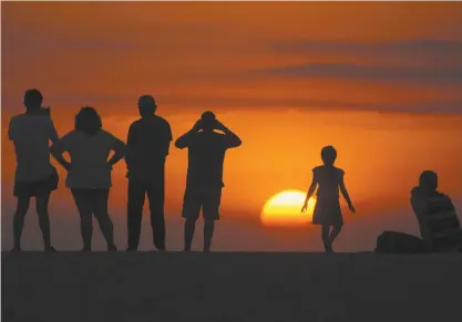  ??  ?? Cientos de turistas y familias completas, sobre todo de México, se reunieron en la playa de Zicatela a ver el atardecer, muchos sin cubrebocas o aplicando la sana distancia. A lo lejos se escuchaba la música de los bares, centros nocturnos y de recreación que estaban operando.