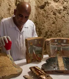  ??  ?? PRICELESS: An Egyptian archaeolog­ist with funeral furniture found in a newly discovered tomb on Luxor’s West Bank