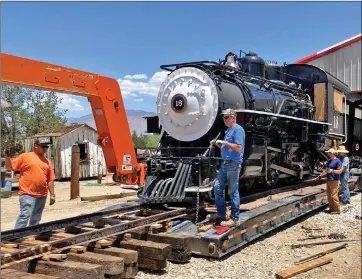  ?? Photo courtesy of Carson and Colorado Railway Co. ?? Slim Princess on Truck: Volunteers from the nonprofit Carson and Colorado Railway Co., get the restored Slim Princess out of her train barn at the Eastern California Museum and get her ready to roll up on trailer bed so she can be hauled to the Great Western Steam Up at the
Nevada State Railroad Museum in Carson City. The locomotive and the Southern Pacific #401 Caboose from Laws will be at the event over the Fourth of July weekend.