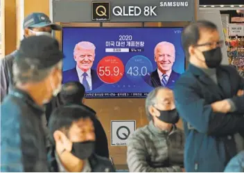  ?? JUNG YEON-JE GETTY IMAGES ?? People stop to watch a television news programs reporting on the U.S. presidenti­al election at a railway station in Seoul, South Korea.