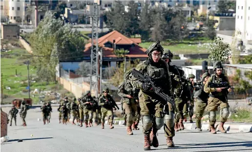  ?? AP ?? Israeli soldiers walk away after they demolished Abu Hmaid family home in al-Amari refugee camp near the West Bank city of Ramallah. Islam Abu Hmaid is accused of killing Israeli soldier by dropping a slab from a roof during a raid last May.