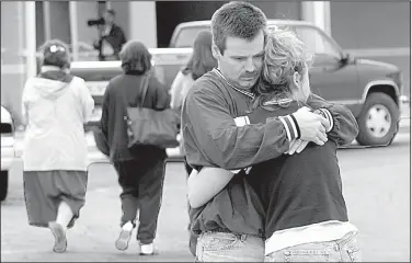  ?? Democrat-Gazette file photo ?? In this photo taken March 24, 1998, football coach Steve Williams and a woman grieve after gunfire at Westside Middle School near Jonesboro killed four students and a teacher, and wounded 10 others in the schoolyard. The shooters were two boys, ages 11...