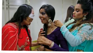  ??  ?? ABOVE: The models help one another to get ready for the runway. LEFT: Reshma in beautiful head jewellery and a high-collared blouse. BELOW: Jesmin Akter, who was blinded in one eye in an acid attack, clearly enjoys the show.