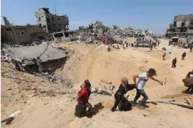  ?? Ahmed Zaqout/Anadolu/Getty Images ?? People return to the ruins of Khan Younis after the Israeli forces’ withdrawal. Photograph: