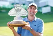  ?? ?? Scottie Scheffler holds up the championsh­ip trophy Sunday after the final round of the Phoenix Open golf tournament in Scottsdale, Ariz. (AP photo/Darryl Webb)