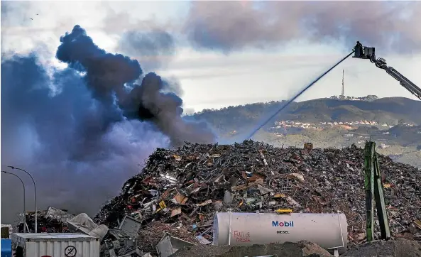  ?? ROSS GIBLIN/STUFF ?? Fire and Emergency crews battle the large blaze in a pile of scrap metal at Macaulay Metals in Lower Hutt’s Seaview suburb yesterday.