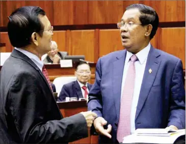  ?? AFP ?? Deputy opposition leader Kem Sokha (left) speaks to Prime Minister Hun Sen at the National Assembly in Phnom Penh earlier this week.
