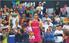  ?? AFP ?? P. V. Sindhu poses on the podium with the medal after winning the women’s singles final against Nozomi Okuhara.