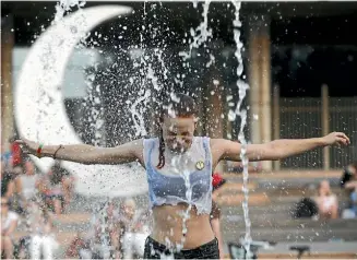  ?? REUTERS ?? A young woman cools off in a fountain during a hot summer day at Gorky Park in Moscow, Russia.