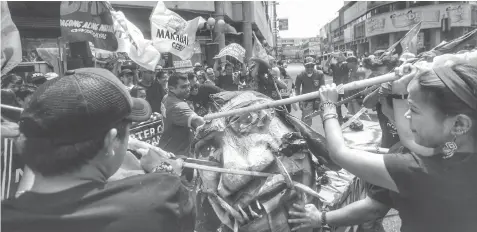  ?? ALDO NELBERT BANAYNAL ?? Members of various cause oriented groups hold a protest action in downtown Cebu City to commemorat­e the Edsa People Power in advance.