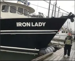  ?? Associated Press ?? In this Dec. 11 photo, Kevin Dunn, a trawler who fishes for groundfish, stands next to his boat as he speaks on the phone with a fish processor at the docks in Warrenton, Oregon.