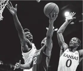  ?? Jamie Squire / Getty Images ?? Baylor’s Jared Butler, center, who scored a game-high 22 points, shoots as Kansas’ Udoka Azubuike, left, and Marcus Garrett defend.