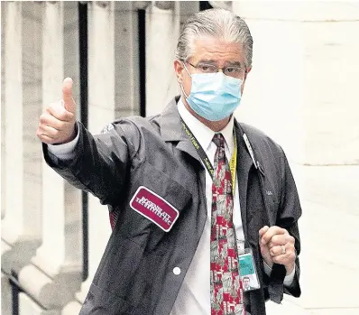  ?? AP ?? Trader Daniel Krieger signals a thumbs up as he arrives at the New York Stock Exchange where the trading floor reopened on Tuesday, May 26.