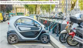  ??  ?? A small electric car is being charged in a free charging station in Milan, Italy.