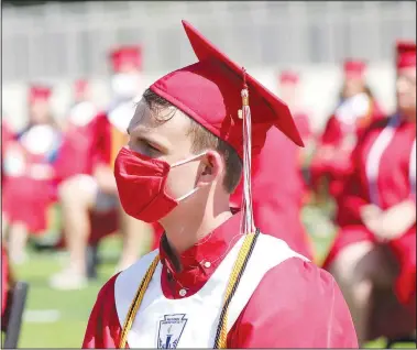  ??  ?? Farmington graduate Carter Bunn listens intently to speakers during the commenceme­nt ceremony. Graduates were allowed to take off their masks during the program but Bunn chose to keep his on.
(NWA Democrat-Gazette/Lynn Kutter)