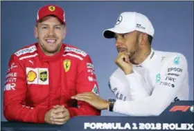  ?? ASSOCIATED PRESS FILE ?? In this Saturday file photo, Mercedes driver Lewis Hamilton, right, of Britain, and Ferrari driver Sebastian Vettel of Germany laugh during a press conference following qualifying at the Australian Formula One Grand Prix in Melbourne. Mercedes blames a...