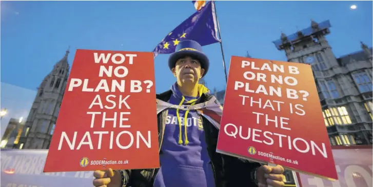  ?? (Photos: AP) ?? A pro-european demonstrat­or holds banners near parliament in London, Thursday. British Prime Minister Theresa May is reaching out to opposition parties and other lawmakers in a battle to put Brexit back on track after surviving a no-confidence vote.