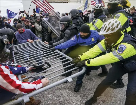  ?? JOHN MINCHILLO — THE ASSOCIATED PRESS ?? Trump supporters try to break through a police barrier Wednesday at the Capitol. As Congress prepares to affirm President-elect Joe Biden’s victory, thousands of people gathered to show their support for President Donald Trump and his claims of election fraud.