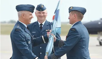  ??  ?? Col. Denis O’Reilly (right) hands off the 15 Wing pennant to Brig.-Gen. Leblanc as Col. Ron Walker looks on.