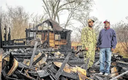  ?? Mark Mulligan / Staff photograph­er ?? Pastor Carlton Wade, right, and the Rev. Rickey Simon stand in the remains of the Greater New Macedonia Baptist Church in Rosharon. A fire, likely from an electrical source, destroyed the more than 100-year-old church early Sunday.