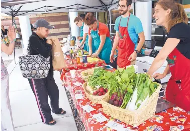  ?? MARLA BROSE/JOURNAL ?? Natalie Donnelly, right, community food projects coordinato­r for the Presbyteri­an Center for Community Health, chats with customers after Melissa Lucero, left, purchased fresh produce at the Mobile Farmers Market on Tuesday.