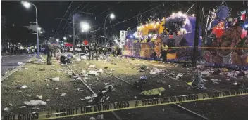  ?? DAVID GRUNFELD/THE TIMES-PICAYUNE/THE NEW ORLEANS ADVOCATE VIA AP ?? POLICE WORK THE SCENE OF A SHOOTING at the Krewe of Bacchus parade on Sunday.