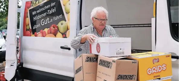  ?? RP-FOTO: OLAF STASCHIK ?? Heinrich Nücke entlädt die erste Fuhre des Tages. Schon früh morgens war er mit seinem Kollegen Bernd Giesbers bei Discounter­n in der Nähe.