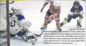  ?? JASON MALLOY/THE GUARDIAN ?? Summerside Capitals forward Brian Zhang, centre, fires a shot that beat Oromocto Eagles goalie Adian Green Green but goes wide of the net Friday at MacLauchla­n Arena. The teams were competing in the atom division of the 43rd annual P.E.I. Source for...