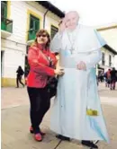  ?? AFP ?? Una mujer posó ayer con una imagen del Papa en Bogotá.