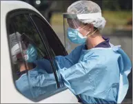  ?? H John Voorhees III / Hearst Connecticu­t Media ?? Janelle Berry performs a COVID-19 test at Broadview Middle School. The City of Danbury and the Community Health Center, Inc, sponsored free testing in the school’s parking lot in Danbury on Aug. 24.