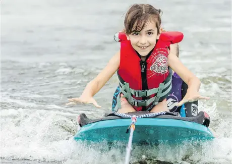  ?? DARREN BROWN ?? Laura Redmond, 6, participat­es in a SkiAbility Ottawa camp on the Rideau River on Tuesday. The camp uses specially designed equipment and teaches people with disabiliti­es water sports, including water-skiing.