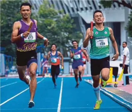  ?? PIC BY ASYRAF HAMZAH ?? Muhammad Ilham Suhaimi (left) crosses the finish line to win the 4x400m relay in record time at the Asean School Games yesterday.