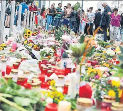  ?? PETER KNEFFEL / EFE ?? Flores y velas ante el centro comercial Olympia en Munich, escenario de la matanza del viernes