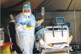  ?? JEROME DELAY AP ?? COVID-19 patients are treated in a makeshift hospital in Pretoria, South Africa, on Friday. South Africa could run out of available hospital beds within the month.