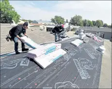  ?? JENNY SPARKS / Loveland Weekly ?? Santiago Quiotioc, left, and his brother Felipe Quiotioc, right, with Peterich Custom Constructi­on, roof a home on the 1300 block of Sylmar Place in Loveland. Peterich Custom Constructi­on, a locally based Owens Corning Platinum roofing company, installed a new roof for U.S. Marine Corps veteran Michael Kempkes as part of the Owens Corning National Roof Deployment Project.