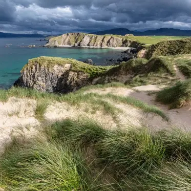  ??  ?? In this image of Farhaid Head, the low light angle brings both the distant cliffs and the foreground grass into dramatic relief, adding depth to the compositio­n. Tonally, the dark clouds contrast with the landscape, evoking the rapidly changing weather typical in the far north of Scotland. The fine details of the foreground dune grass are enjoyable for the eye to move around and linger on.