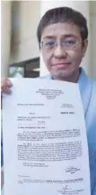  ?? — AFP ?? Maria Ressa, CEO and Executive Editor of online portal Rappler, shows the warrant of arrest order after posting bail in Manila.